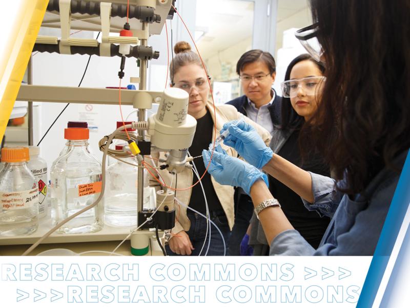 Student researcher with gloves demonstrating lab equipment.